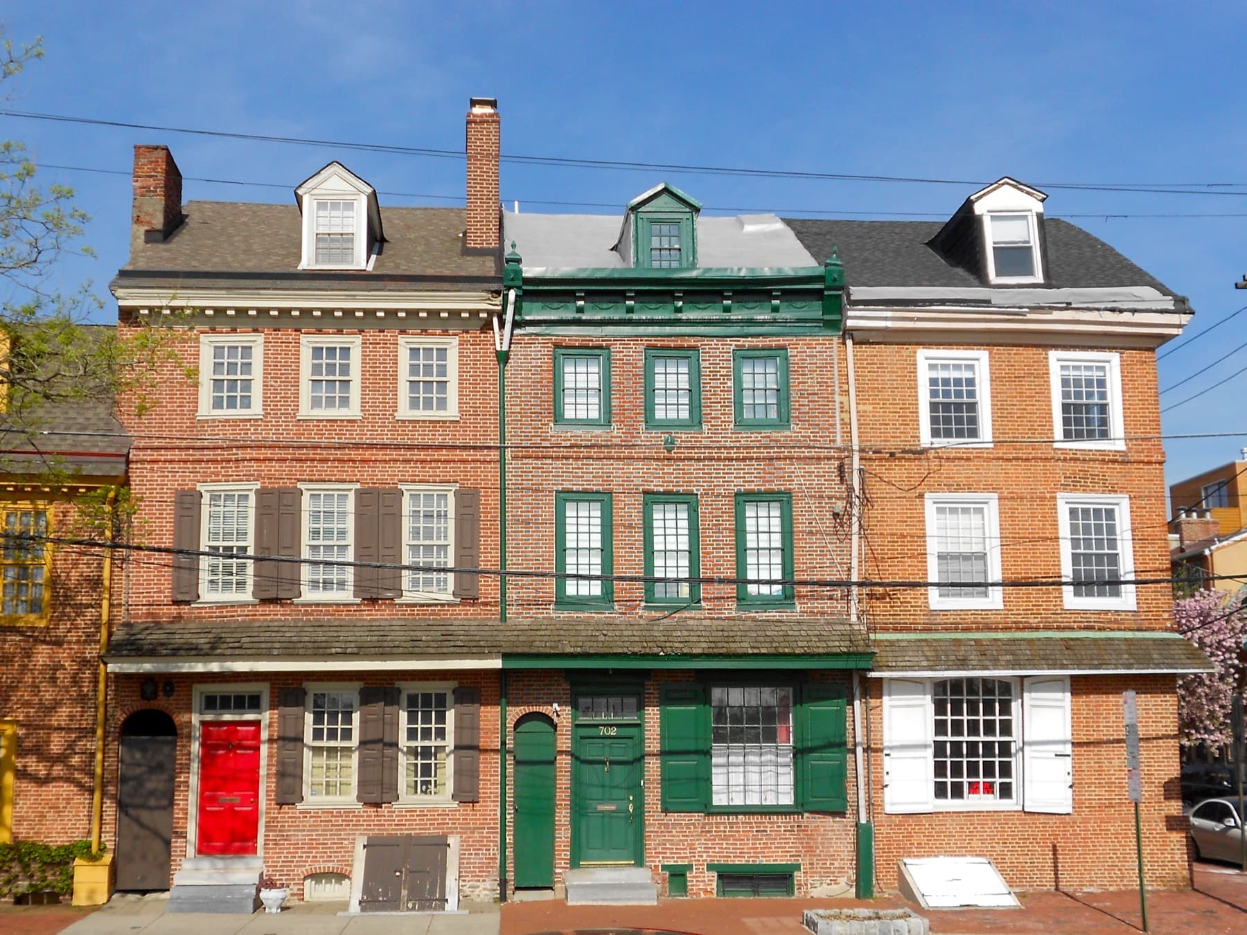 Casas en hilera de ladrillo con persianas verdes y puertas rojas y verdes en South Front Street, Philadelphia